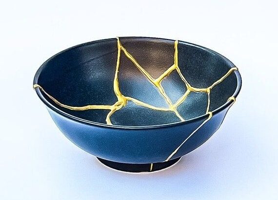 Dunkelblaue Keramikschale mit markanten goldenen Kintsugi-Rissen